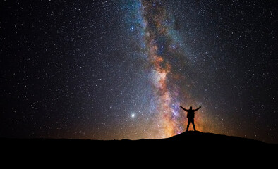 Man in front of the universe with his arms raised