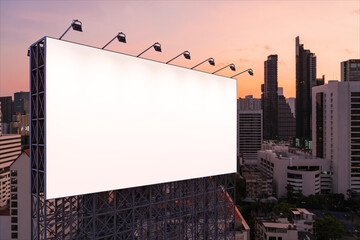 Blank white road billboard with Bangkok cityscape background at night time. Street advertising poster, mock up, 3D rendering. Side view. The concept of marketing communication to sell idea.