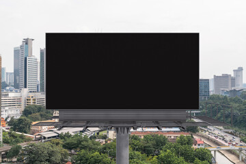Obraz premium Blank black road billboard with Kuala Lumpur cityscape background at day time. Street advertising poster, mock up, 3D rendering. Front view. Concept of marketing to promote or sell services or ideas.