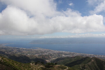 Fototapeta na wymiar Clouds above the city, great view on the detroit of Messina