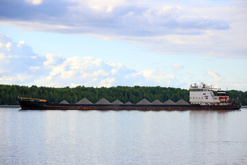 transportation of crushed stone along the river on cargo ship