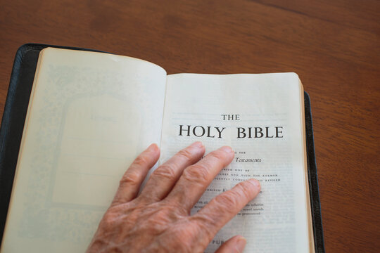 A hand resting on an open Bible