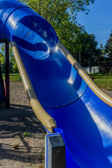 Vertical closeup shot of an empty blue slider on a public playground 