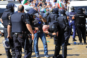 Sofia, Bulgaria on September 2, 2020: Heavily armed police officers wash their eyes from spraying...