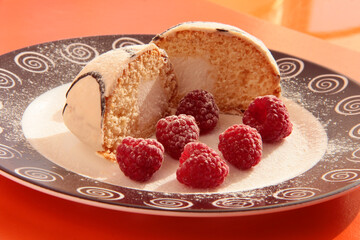 Delicious breakfast. Raspberry berries with sponge cake in powdered sugar on a bright background
