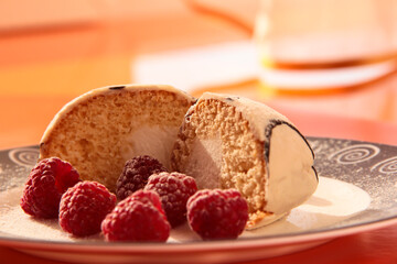 Delicious breakfast. Raspberry berries with sponge cake in powdered sugar on a bright background