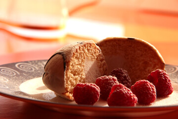 Delicious breakfast. Raspberry berries with sponge cake in powdered sugar on a bright background