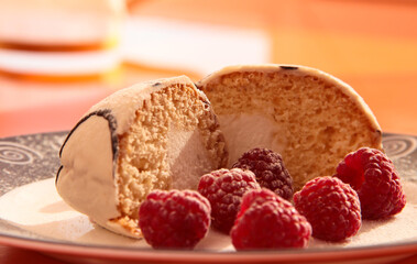 Delicious breakfast. Raspberry berries with sponge cake in powdered sugar on a bright background