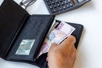 Hand is counting money of unknown old person on white background,above view