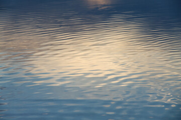 The calm water surface with reflections of different colors. Background.