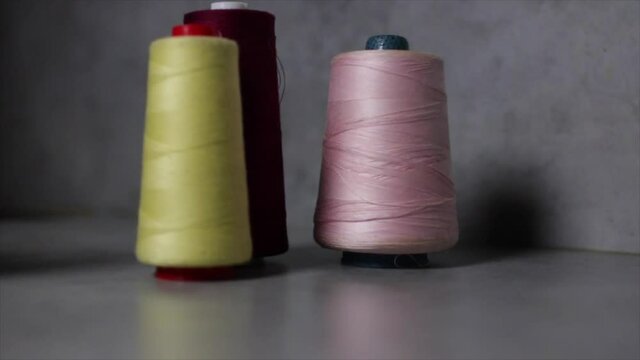 mujer tomando carretes de hilos