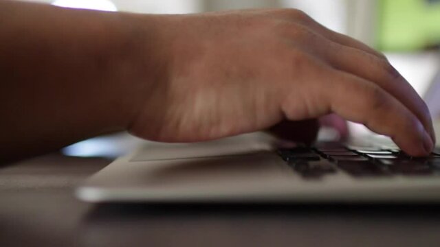 manos de hombre sobre el teclado de laptop