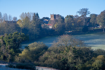 Frosty fields and village church in Oxfordshire on a sunny autumn day