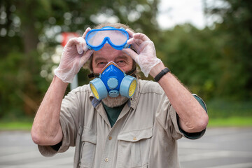 Hampshire, England, UK. 2020. Portrait of a man wearing gloves,  a mask with filter and goggles  during Covid-19 outbreak in the UK.