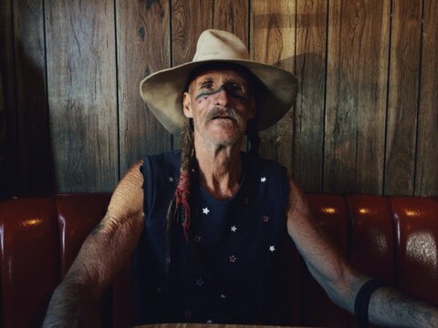 Rough Aged Man Sits in a Diner