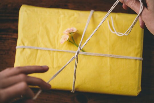 Hands tying a knot wrapping a gift