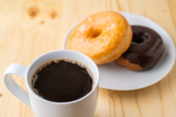 coffee and doughnut on bright pine table