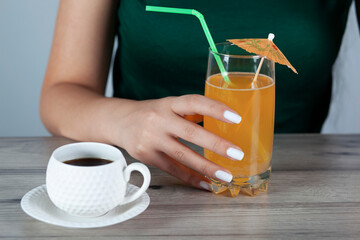  woman hand with  Orange juice in coffee