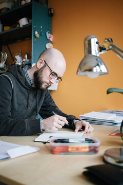 A designer sketching behind his desk at his home office
