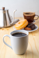coffee and doughnut on bright pine table