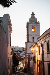 Narrow street in front of Santa Maria church. Magic light at dusk. Lagos, Algarve Coast, Portugal