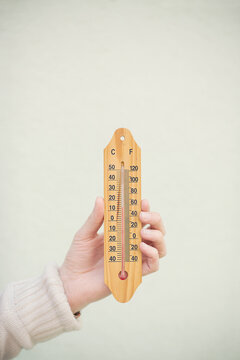 hand holding a thermometer outside