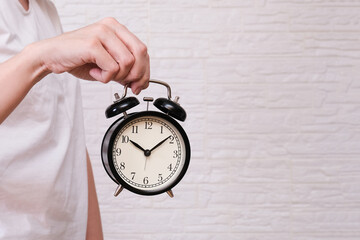 Woman holding an alarm clock showing 10 oclock, people should value and appreciate time, deadline concept copy space