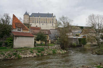 old stone castle and church above the village by the river in france