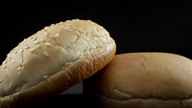 Close-up frame of small bread on a black studio background. Close-up of an appetizing bread roll. Food style food concept. High quality 4k footage