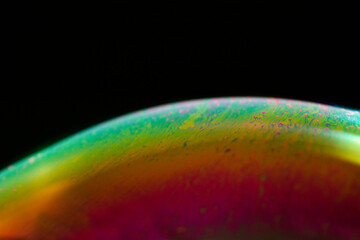 Detail of light in a soap bubble, allusion to the micro universe in a studio with a black background, use of natural and artificial light.