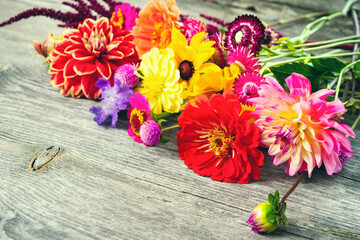 Holiday autumn bouquet. Frame of colorful flowers arranged on old wooden background. Copy space for your advertising text message or promotional content.
