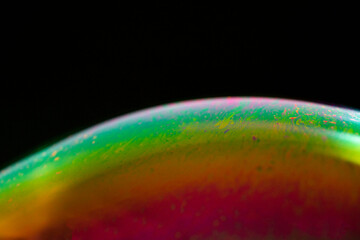 Detail of light in a soap bubble, allusion to the micro universe in a studio with a black...