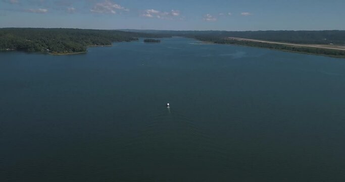 Aerial drone shot of a boat traveling on the lake to the jungle in Peten, Guatemala
