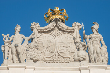 Obraz premium Roof statues of Imperial symbols and coat of arms at Alberina museum, near Palmenhaus and Neue Burg Palace garden in historical downtown of Vienna, Austria