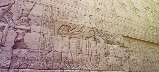 Fototapeta na wymiar Egypt Hieroglyphic god face got destroyed at Edfu Horus temple feature wall