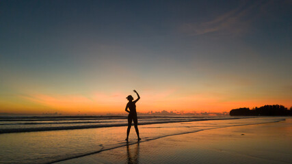young woman exercising on the beach at beautiful sunset