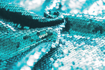 AI aqua blue trendy color of year 2021 sequin fabric texture. Shiny sparkling background. Clothing piece of glitter metallic for a glamorous party, celebration. Close-up.
