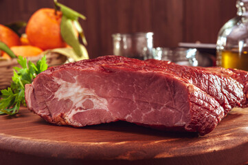 Piece of bacon with parsley branch on the wood cutting board - Close-up