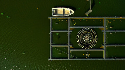 Rowing boat on lake near the not working fountain contruction