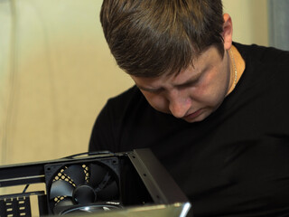 a young man builds a personal computer. workshop. repair. computer case.