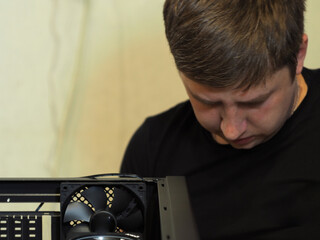 a young man builds a personal computer. workshop. repair. computer case.