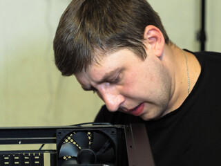 a young man builds a personal computer. workshop. repair. computer case.