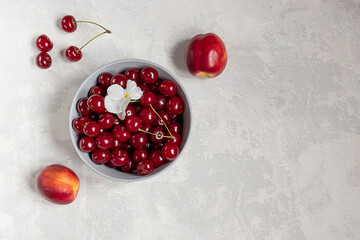 Fresh sweet cherries and nectarines on grey concrete background with copy space