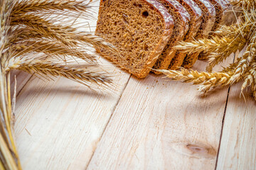 Whole wheat bread. Fresh loaf of rustic traditional bread with wheat grain ear or spike plant on...