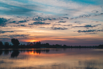 Fototapeta na wymiar Summer landscape of Belarus. Beautiful sunrise over the Pripyat river. Reflections of clouds on the water.