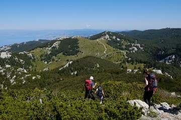 Fototapeta na wymiar The beautiful Premuziceva Staza mountain path, Velebit National Park, Dinaric Mountains, Croatia. Silhouettes of walking tourist.