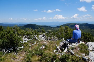 The beautiful Premuziceva Staza mountain path, Velebit National Park, Dinaric Mountains, Croatia. Silhouette of resting tourist on Veliki Zavizan peak. 