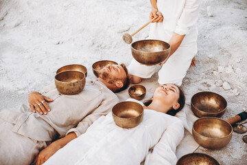 01.06.2019 Vinnitsa, Ukraine: group therapy with Tibetan singing bowls for a girl and a boy lying...