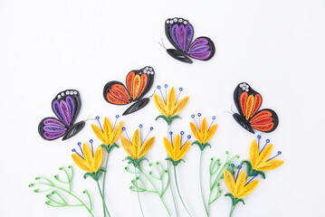 Beautiful butterflies and yellow flowers, isolated on white background. Hand made of paper quilling technique.