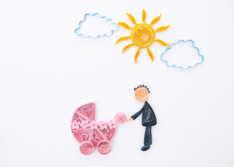 Father with a newborn baby. Parrent with carriage. Hand made of paper quilling technique.